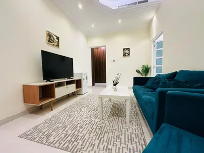 a living room with a blue couch and a tv at Dubai Al Barsha Villa Fully Furnished Luxury Private Master Room Ensuite Huge Space Deluxe in Dubai