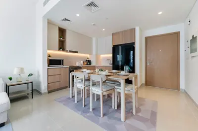 a kitchen with a table and chairs in a room at FAM Living - Elegant 2BR with Park & Creek Panorama in Dubai