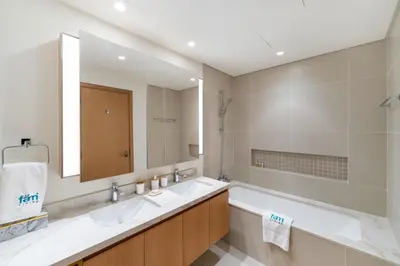 a bathroom with two sinks and a large mirror at FAM Living - Elegant 2BR with Park & Creek Panorama in Dubai