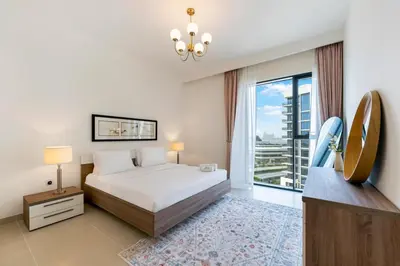 a bedroom with a bed and a large window at FAM Living - Elegant 2BR with Park & Creek Panorama in Dubai