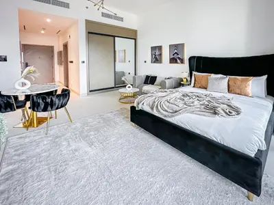 a bedroom with a large bed and a living room at Skyline Views Chic 1BR with Canal Vibes in Dubai