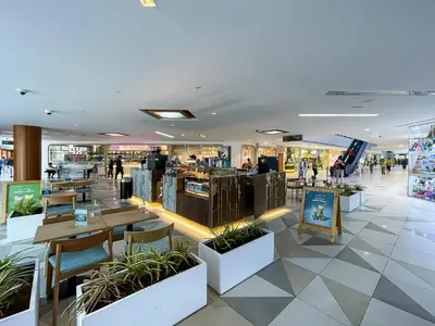 a restaurant with tables and chairs in a shopping mall at Skyline Views Chic 1BR with Canal Vibes in Dubai