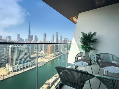 a balcony with chairs and a view of a city at Skyline Views Chic 1BR with Canal Vibes in Dubai
