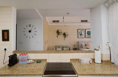 a kitchen with two counters and a clock on the wall at Modern Studio with Marina Skyline view in JLT - Prime Location near Metro in Dubai