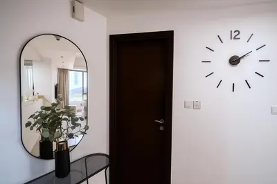 a mirror and a clock on a wall next to a door at Modern Studio with Marina Skyline view in JLT - Prime Location near Metro in Dubai