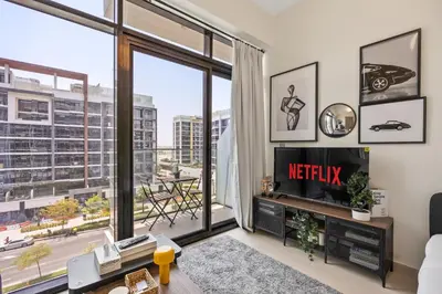 a living room with a tv and a large window at Elite Escape - Boho Getaway in Azizi Riviera 16 in Dubai