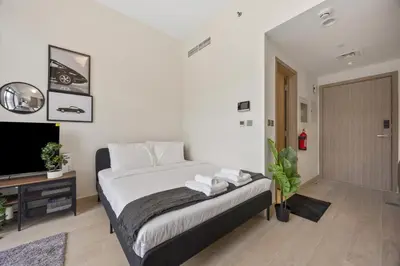 a bedroom with a bed and a flat screen tv at Elite Escape - Boho Getaway in Azizi Riviera 16 in Dubai