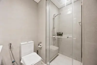 a bathroom with a toilet and a glass shower at Elite Escape - Boho Getaway in Azizi Riviera 16 in Dubai