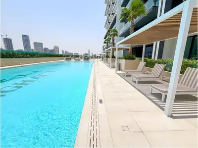 a swimming pool with chaise lounge chairs next to a building at 2 Bed, Private Pool, Big Terrace, Solysian Stay in Dubai