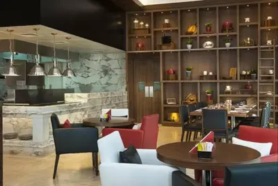 a restaurant with tables and chairs and a bar at Vogue Business Bay Damac Cour Jardin close to Downtown, Burj Khalifa and Dubai Mall, Studio Apartment with City View, Access to all Amenities in Dubai