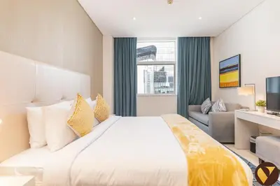 a hotel room with a large bed and a couch at Vogue Business Bay Damac Cour Jardin close to Downtown, Burj Khalifa and Dubai Mall, Studio Apartment with City View, Access to all Amenities in Dubai