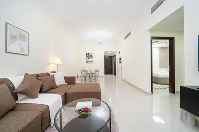 a living room with a couch and a table at Bright and Stylish 2 Bed Home Opposite Circle Mall in Dubai