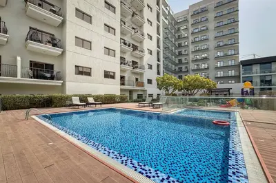 a swimming pool in front of a building at Bright and Stylish 2 Bed Home Opposite Circle Mall in Dubai