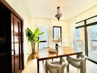 a dining room with a wooden table and chairs at Only family Walking distance to Dubai Mall in Dubai