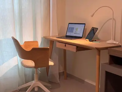 a laptop computer sitting on a wooden desk with a chair at Premium 1BR in Dubai Marina King Bed, Marina View, Near JBR, Beach & Vibrant Nightlife in Dubai