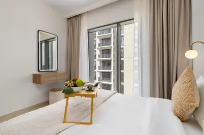 a bedroom with a white bed and a large window at Maison Privee - Charming Urban Escape with Resort-Style Facilities in Dubai