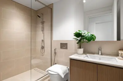 a bathroom with a shower and a toilet and a sink at Maison Privee - Charming Urban Escape with Resort-Style Facilities in Dubai