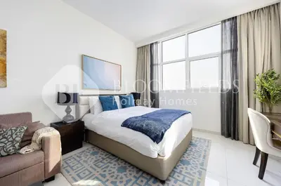 a bedroom with a king sized bed and a couch at Bloomfields Elegant Stu Damac Ghalia in Dubai