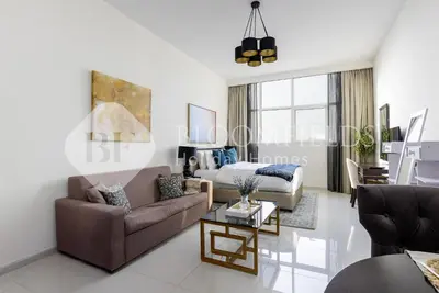 a living room with a couch and a bed at Bloomfields Elegant Stu Damac Ghalia in Dubai
