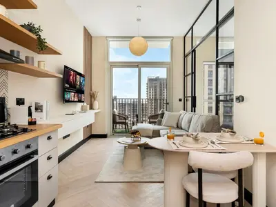 a kitchen and living room with a table and a couch at Stylish 1BR in Socio Pool, Cinema & Game Lounge in Dubai