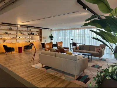 a living room with a couch and chairs and tables at Stylish 1BR in Socio Pool, Cinema & Game Lounge in Dubai