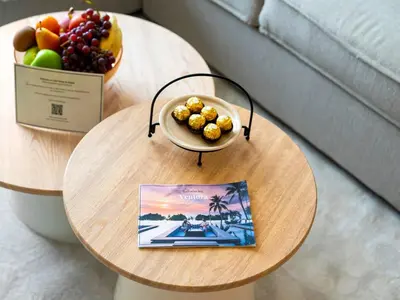 a table with a bowl of fruit and a book at Stylish 1BR in Socio Pool, Cinema & Game Lounge in Dubai