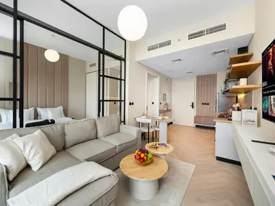 a living room with a couch and a table at Stylish 1BR in Socio Pool, Cinema & Game Lounge in Dubai