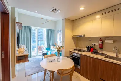 a kitchen with a table and a dining room at Modern 1BR in Business Bay Balcony Pool Access in Dubai