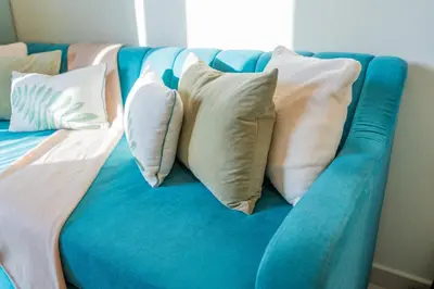 a blue couch with several pillows on it at Modern 1BR in Business Bay Balcony Pool Access in Dubai