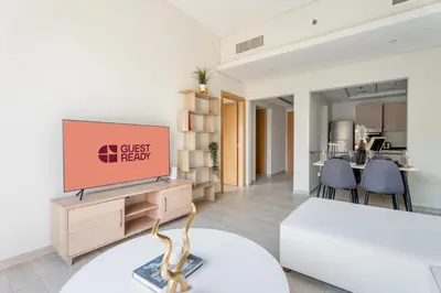 a living room with a tv and a table at GuestReady – Relax Stay w Balcony & Pool View in Dubai