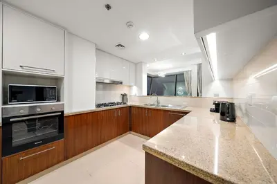 a large kitchen with wooden cabinets and a counter top at FIRST CLASS 3BR Stunning Burj Khalifa View in Dubai