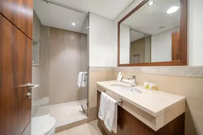 a bathroom with a sink and a shower and a mirror at FIRST CLASS 3BR Stunning Burj Khalifa View in Dubai