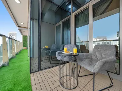 a balcony with chairs and a table on a building at 64th Floor Infinity Pool 2BR Best Burj Khalifa View in Dubai
