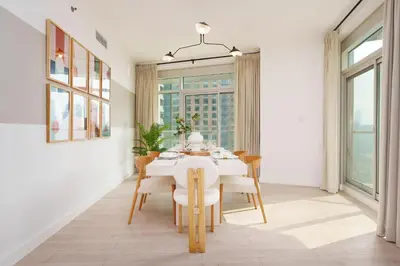 a dining room with a white table and chairs at Burj Views East, Downtown - Mint Stay in Dubai