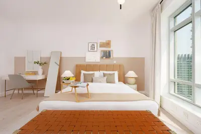 a white bedroom with a large bed and a desk at Burj Views East, Downtown - Mint Stay in Dubai