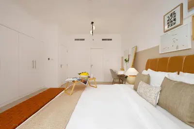 a bedroom with a large white bed and a table at Burj Views East, Downtown - Mint Stay in Dubai