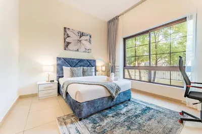 a bedroom with a bed and a large window at Spacious 4BR Plus Maids Villa, Near Avenue Mall, Cycle Park & Sports Complex - 15 Mins to Downtown Dubai, Nad Al Shiba Third by Deluxe Holiday Homes in Dubai