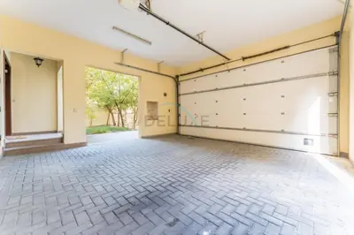 an empty garage with a white garage door at Spacious 4BR Plus Maids Villa, Near Avenue Mall, Cycle Park & Sports Complex - 15 Mins to Downtown Dubai, Nad Al Shiba Third by Deluxe Holiday Homes in Dubai