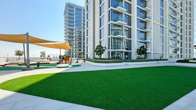 a large apartment building with a green lawn in front of it at DAYF-JFH Spacious Apartment 4 PAX with Magical Lagoon Views in Dubai