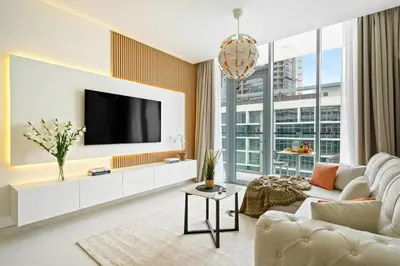 a living room with a white couch and a tv at DAYF-JFH Spacious Apartment 4 PAX with Magical Lagoon Views in Dubai