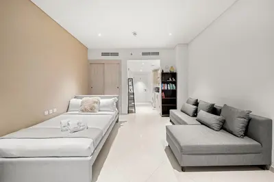 a living room with two couches and a couch at FIRST CLASS Studio Infinity Pool and Luxe Vibes in Dubai