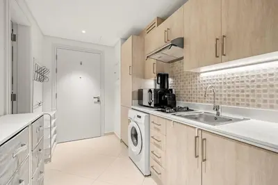 a kitchen with a sink and a washing machine at FIRST CLASS Studio Infinity Pool and Luxe Vibes in Dubai