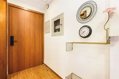 a hallway with a door and a clock on the wall at FIRST CLASS Studio Cozy Vibes and Stylish Escape in Dubai