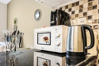 a microwave sitting on a counter with a tea kettle at FIRST CLASS Studio Cozy Vibes and Stylish Escape in Dubai