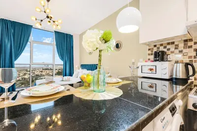a kitchen with a table with a vase of flowers on it at FIRST CLASS Studio Cozy Vibes and Stylish Escape in Dubai