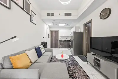 a living room with a couch and a tv at Cosy Apartment in Dubailand near Global Village in Dubai
