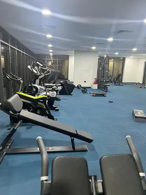 a gym with a row of treadmills and a motorcycle at Cosy Apartment in Dubailand near Global Village in Dubai