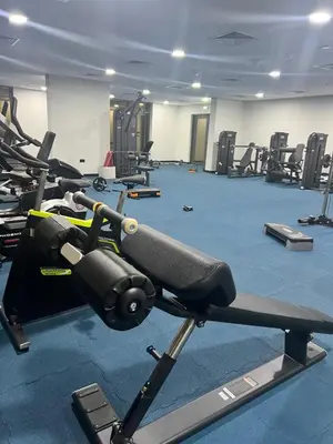 a gym with rows of treadmills and machines at Cosy Apartment in Dubailand near Global Village in Dubai
