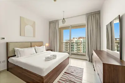 a bedroom with a large bed and a large window at FIRST CLASS 1BR Modern Urban Retreat in Dubai