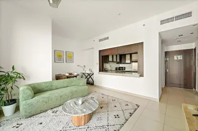 a living room with a green couch and a table at FIRST CLASS 1BR Modern Urban Retreat in Dubai